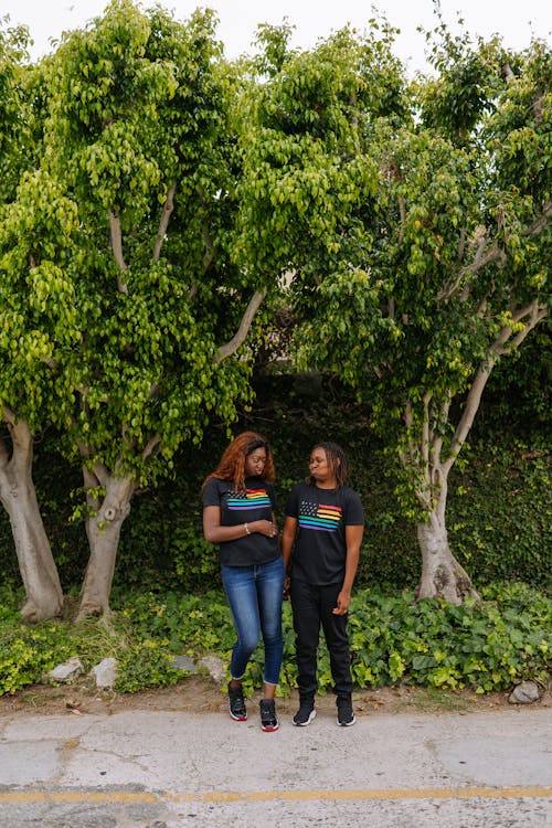 Mujer En Blue Denim Jeans De Pie Junto Al árbol Verde