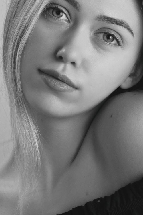 Free Black and white close-up portrait of a young woman with soft expression. Stock Photo