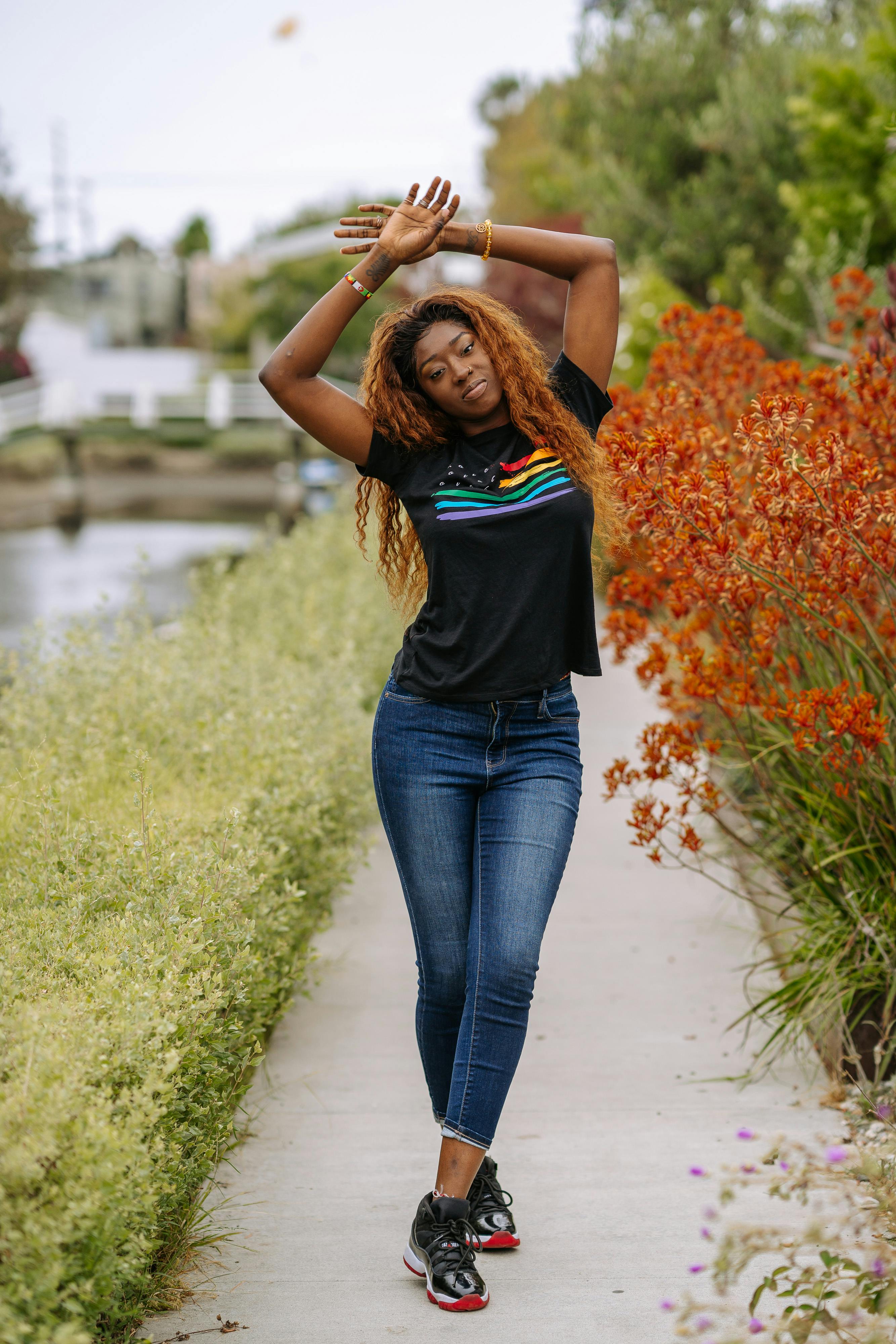 a woman in a gay pride shirt raising her arms