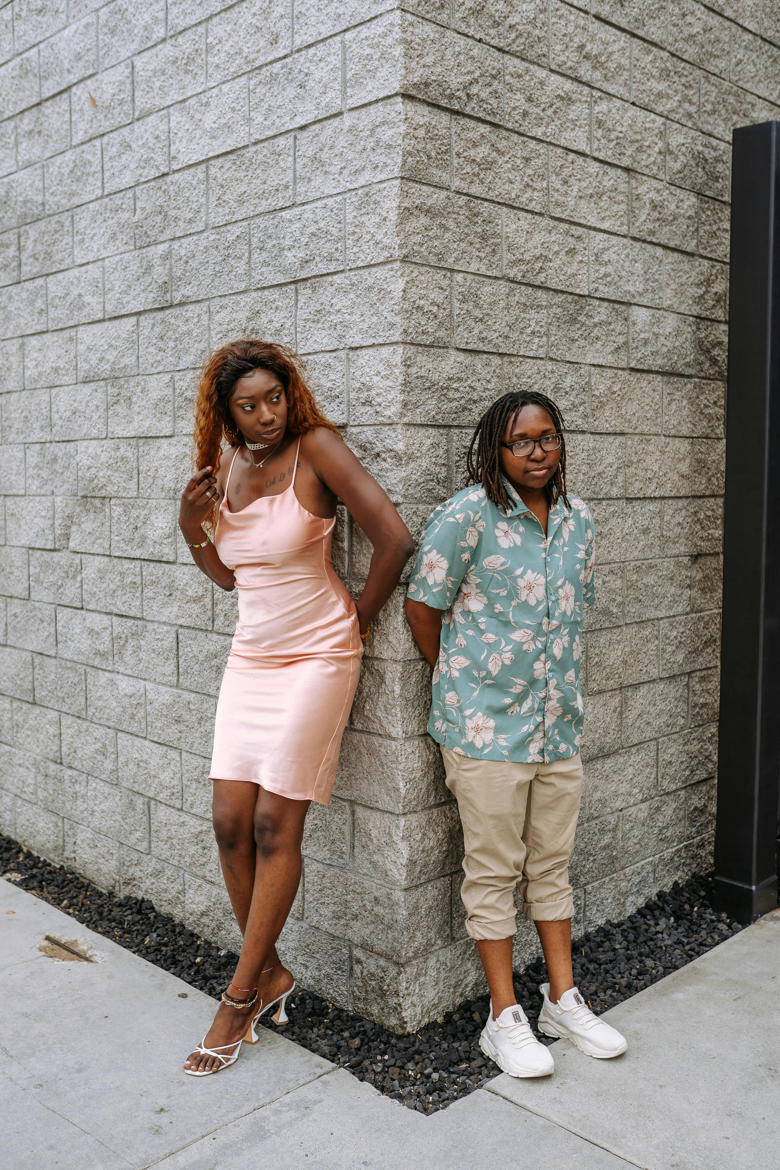 2 women standing beside gray concrete wall