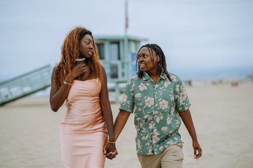 Shallow Focus Photo of Couple Walking on the Beach while Holding Hands
