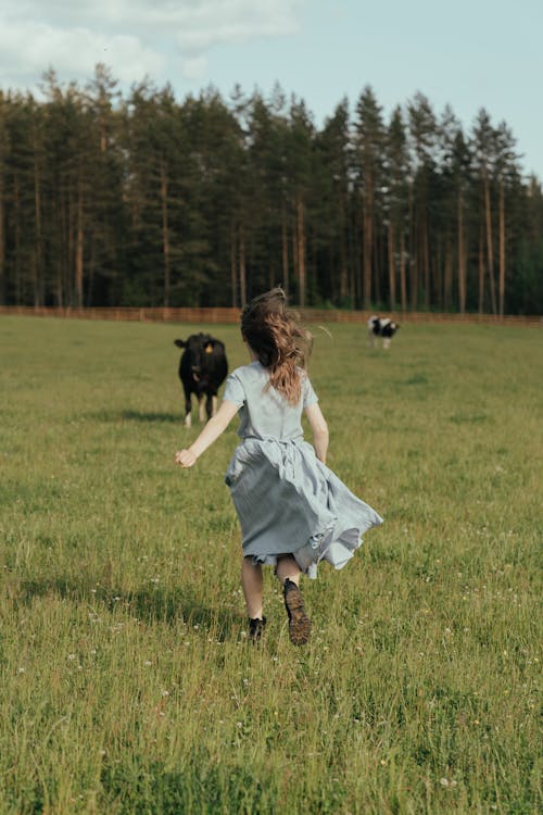 Girl in White Dress Running on Green Grass Field