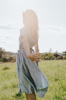 阳光明媚的草地上，一个女人快乐地旋转，拥抱自由和自然