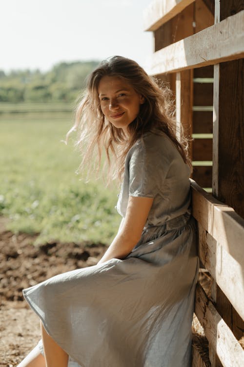 Woman in White Dress Sitting on Brown Wooden Bench