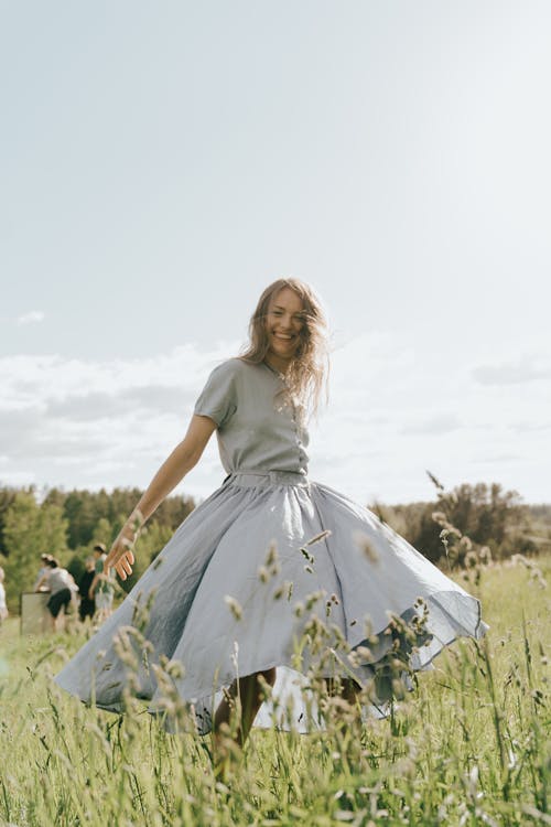 Woman in White Dress Standing on Green Grass Field