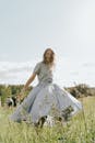 一个无忧无虑的女人在阳光明媚的日子里在草地上快乐地旋转，象征着自由和幸福