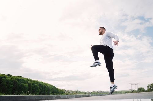 Free An athletic man jumps outdoors, showcasing dynamic movement against a scenic backdrop. Stock Photo