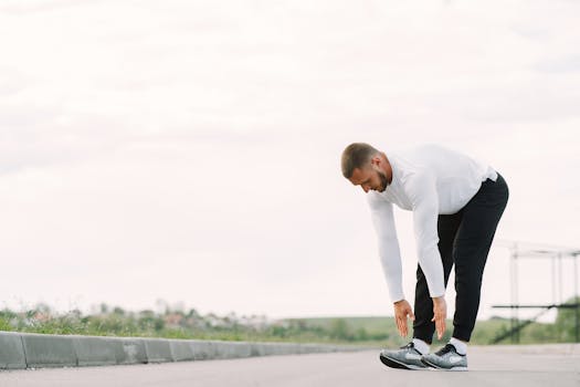 Healthy lifestyle concept with a man stretching outside in activewear, preparing for exercise.