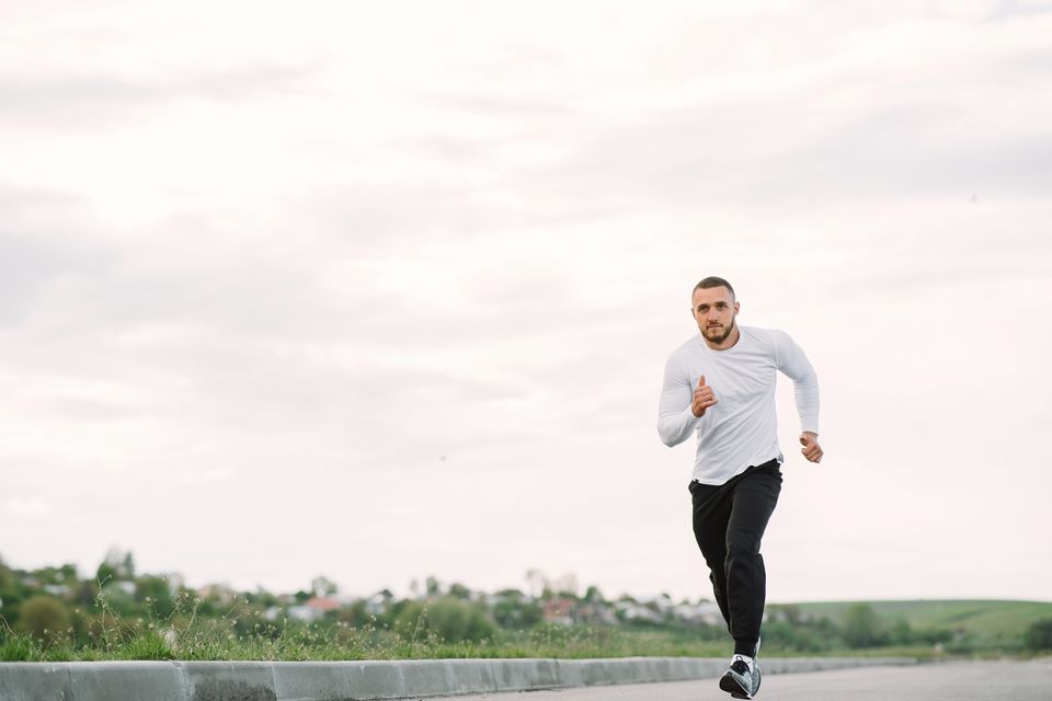 A man running on an empty road in sportswear