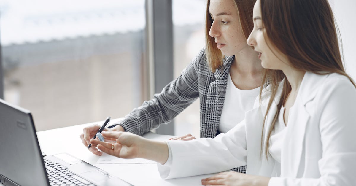 Two professional women engaged in a collaborative work session in a bright modern office.