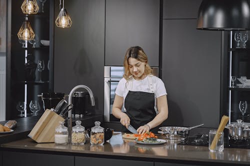 Woman slicing Food on Kitchen Counter 