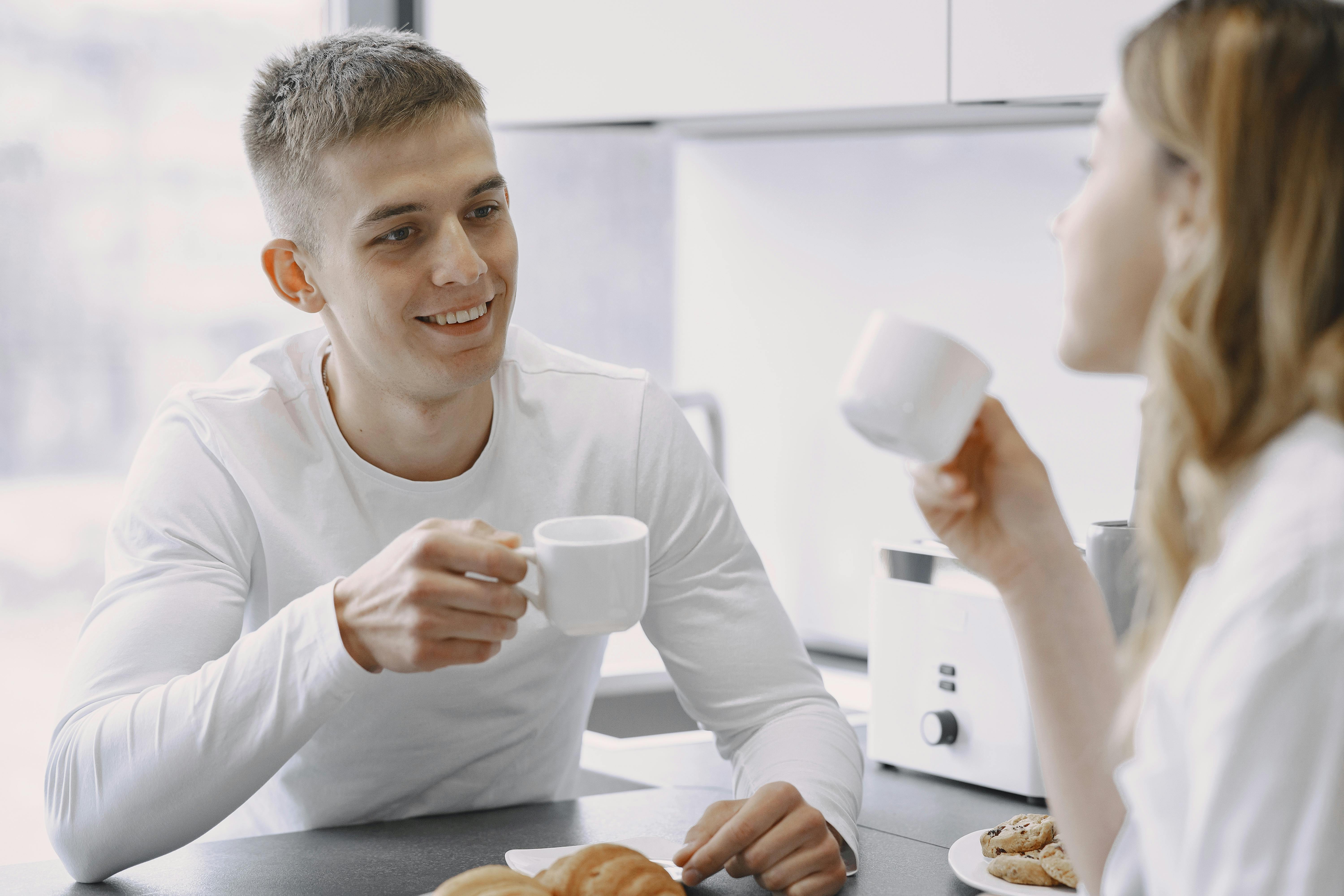Smiling couple sharing a moment over coffee, highlighting warmth and connection.
