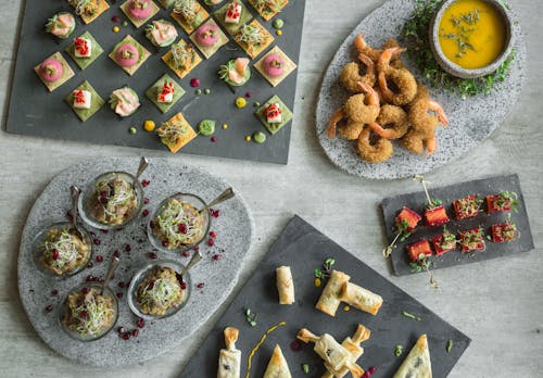 An Arrangement of Assorted Food Platings on Gray Surface