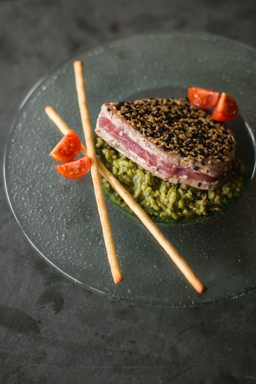 A Food Plating of Green Rice with Meat on Top
