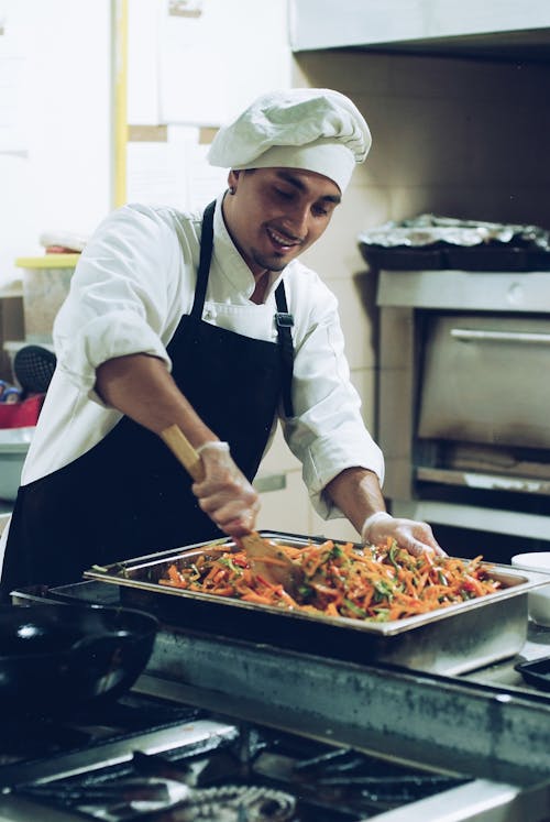 A Male Chef Mixing the Food on the Food Pan