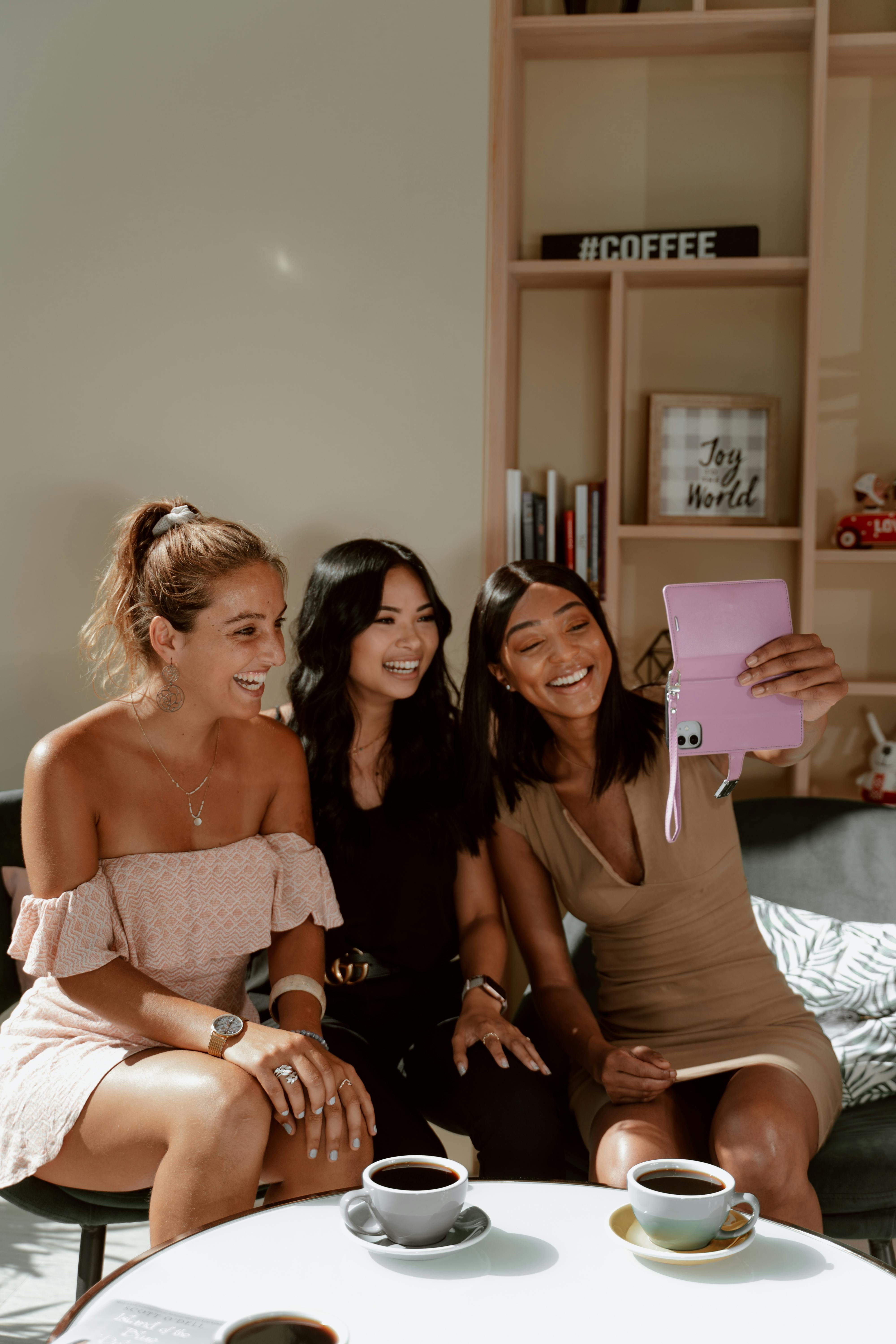 三名女子在家里喝咖啡时微笑着自拍