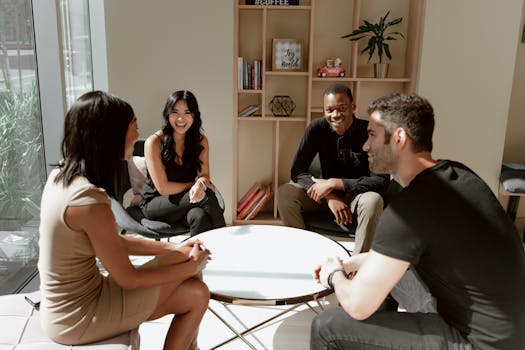Group of diverse adults in a casual meeting around a table indoors.