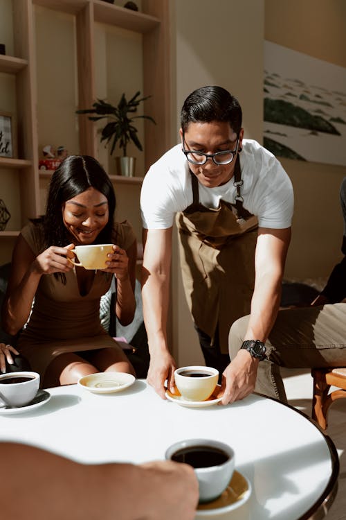 Waiter serves Coffee on Table