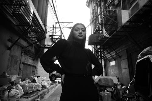 
A Grayscale of a Woman in an Alley