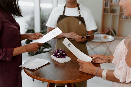 People reviewing a restaurant menu with a gift on a table indoors.