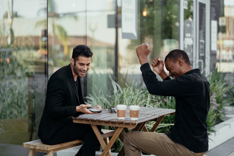 Happy Male Colleagues Talking To Each Other