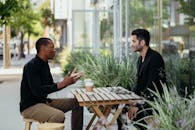 两名男子在户外咖啡馆进行商务会议