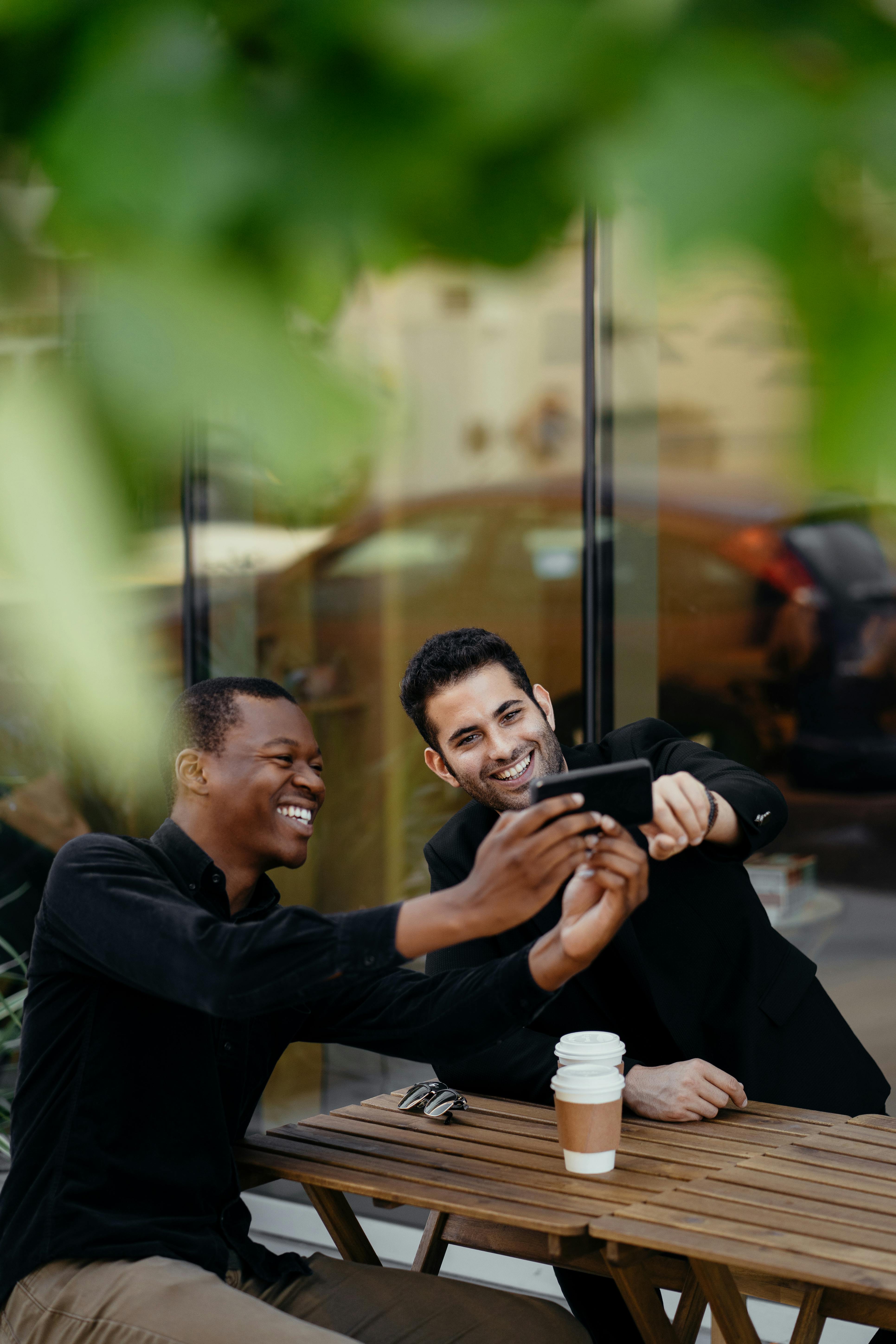 two men smiling while taking a selfie