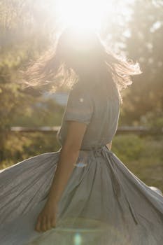 黄昏的阳光下，一位年轻女子优雅地旋转，拥抱夏日户外无忧无虑的本质