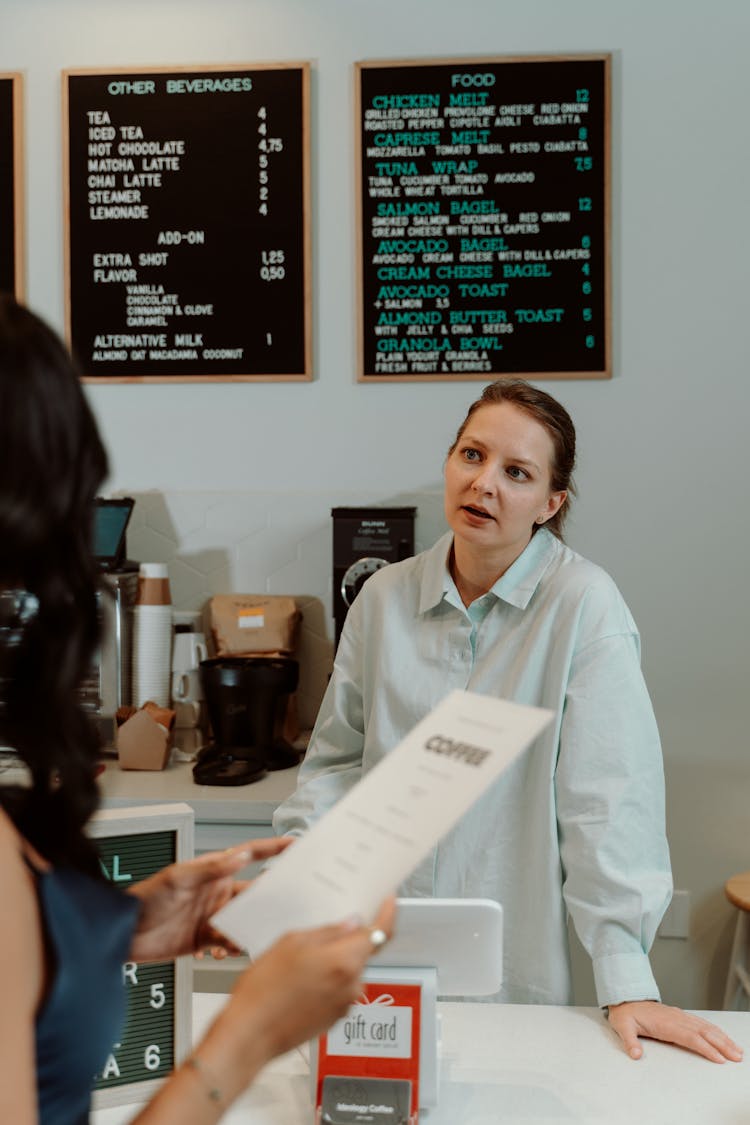 Cashier Behind A Counter In Front Of A Customer