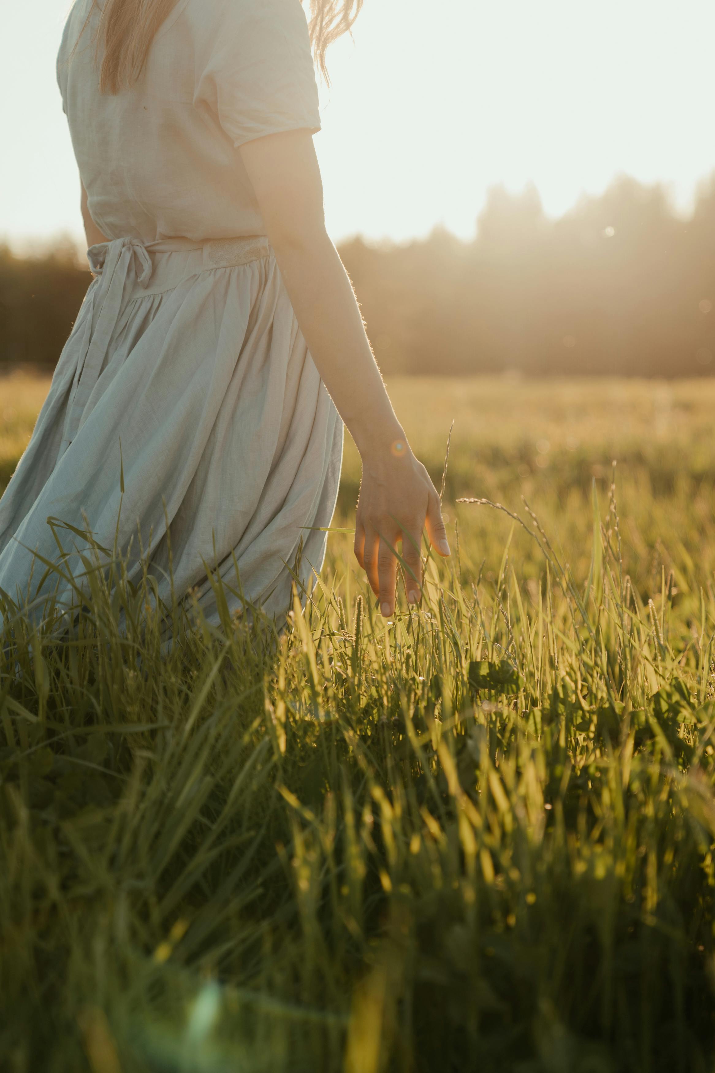 woman in white dress standing on green grass field
