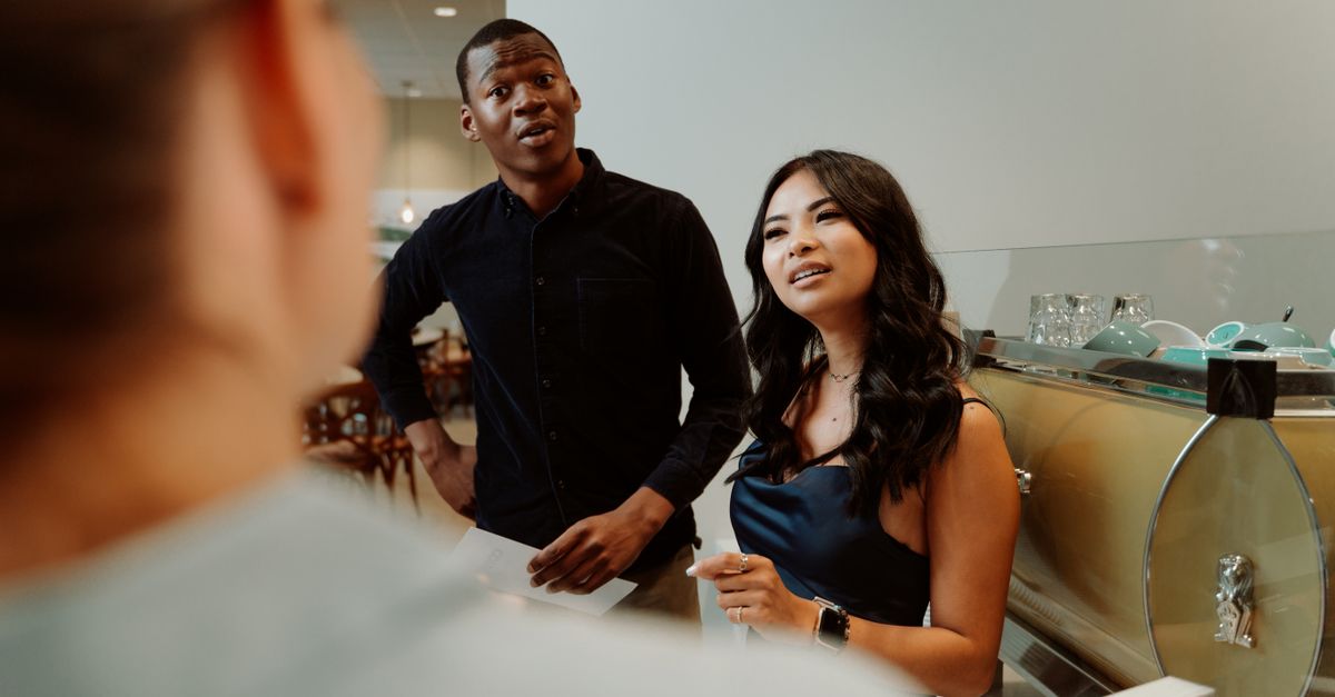 Two diverse young adults having a deep conversation over coffee, looking engaged and respectful
