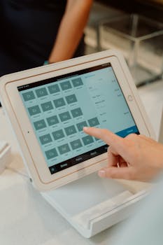 Close-up of a touchscreen tablet used as an order terminal with a hand interacting, featuring modern technology.