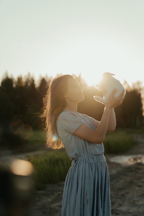 Woman in White Dress Holding Heart Shaped Balloon