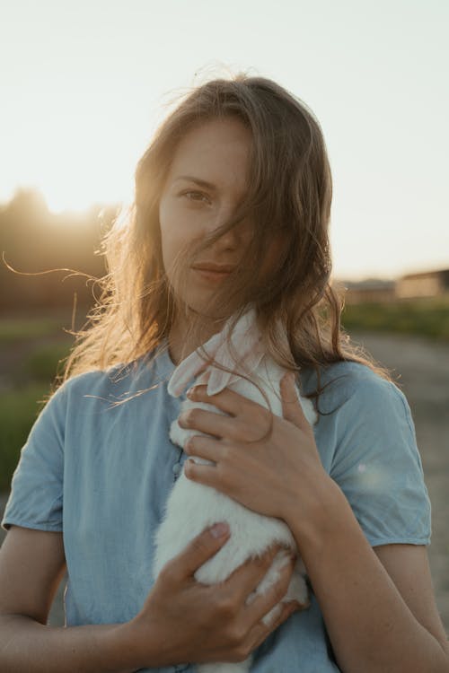 Girl in Blue T-shirt Holding White Textile