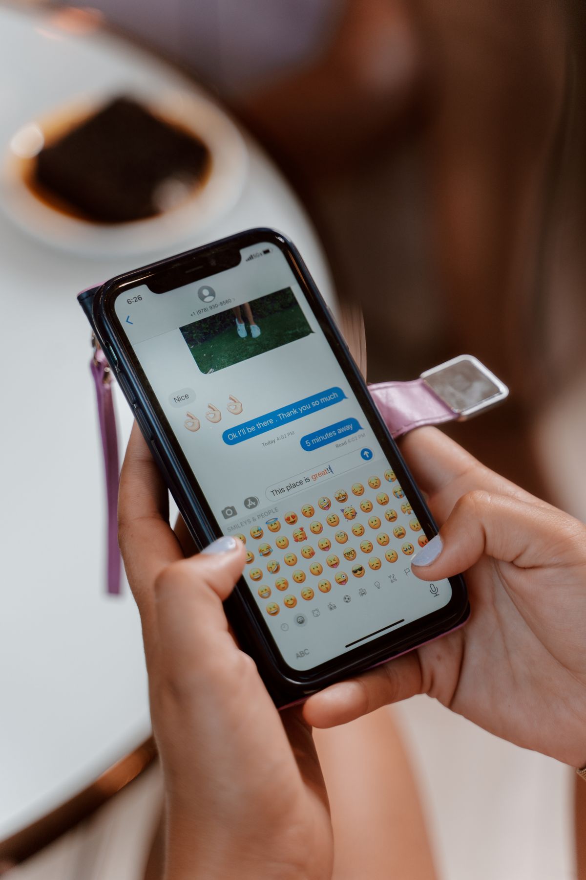 A close-up of a person typing a text message on a smartphone