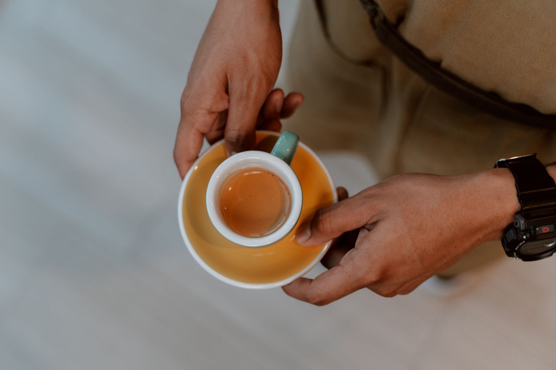 A person holding a ceramic cup with freshly brewed espresso, photographed from above.. pexels, person, holding