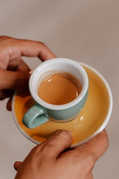 一个人拿着陶瓷杯，杯里装着新煮的咖啡