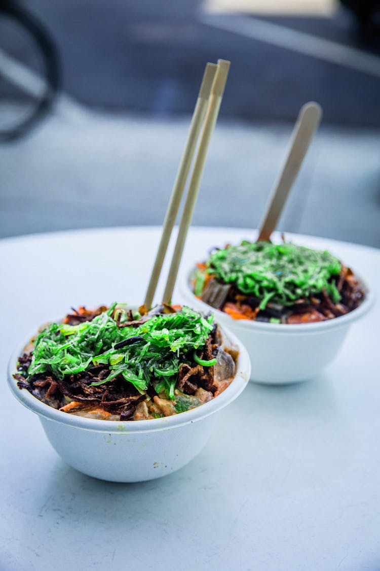 A Pair Of Bowls With Delicious Food