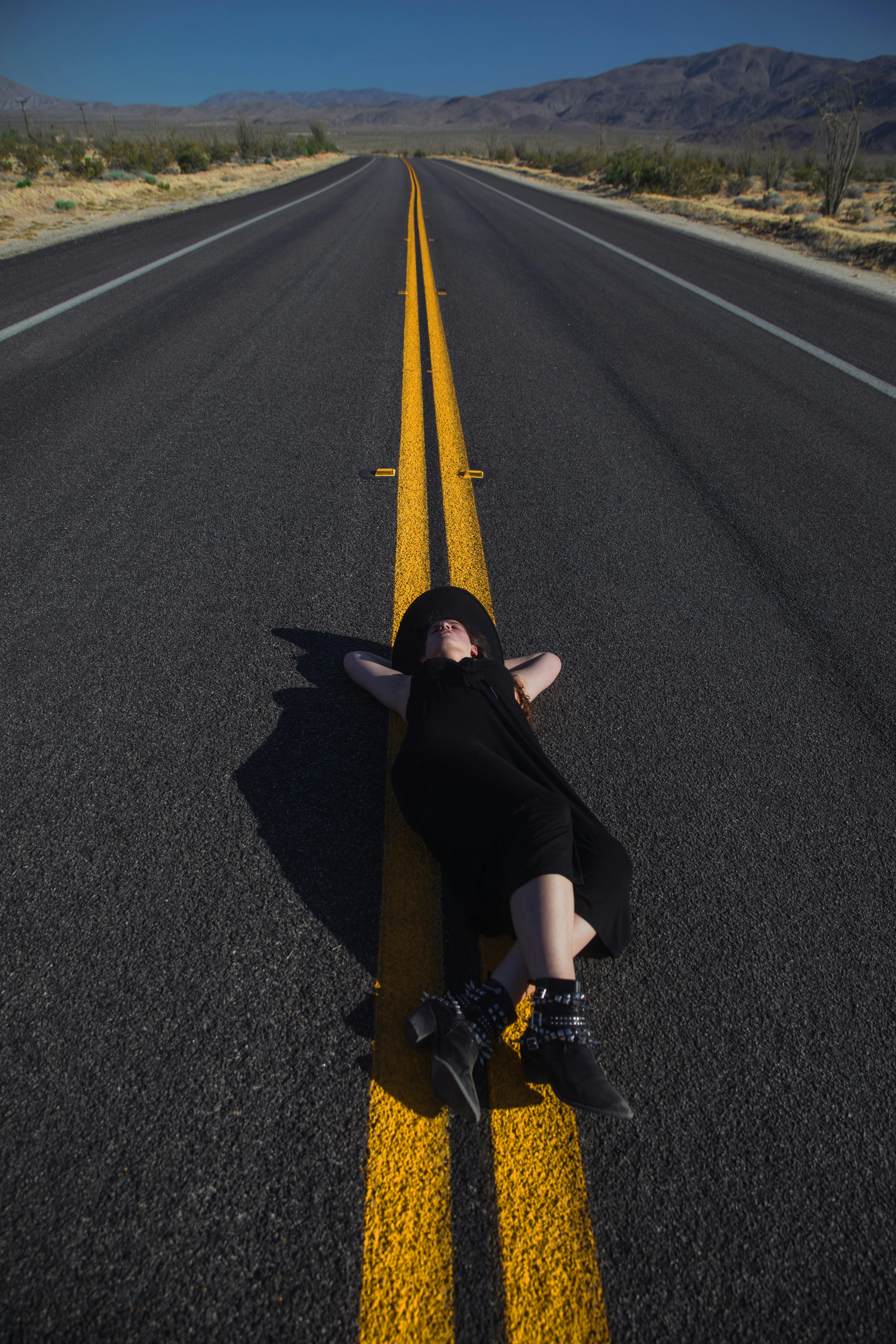 a woman lying down on the road