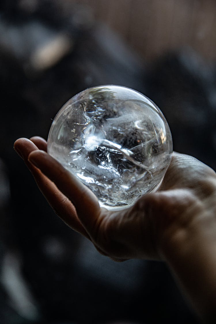 A Person Holding A Clear Crystal Ball