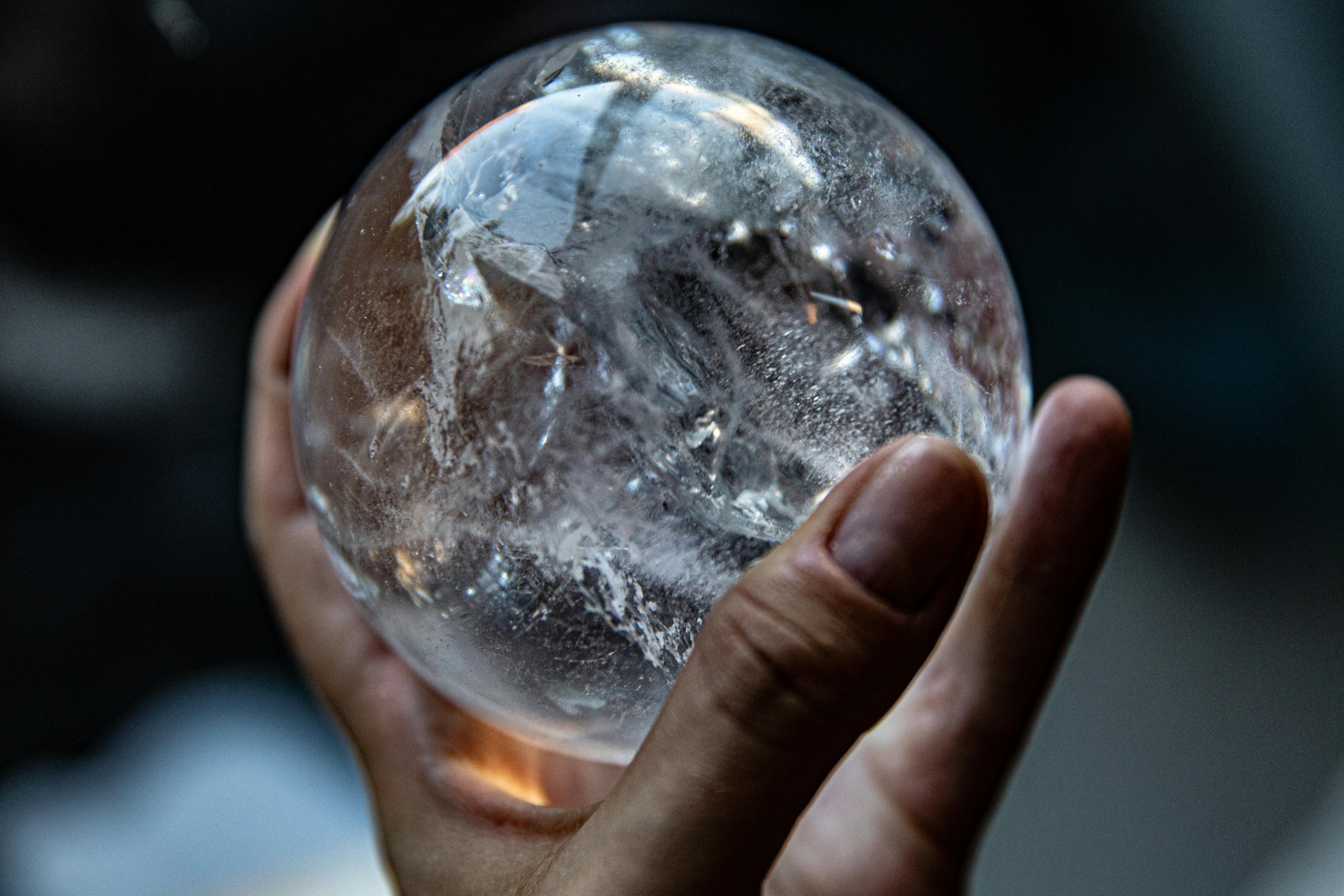 person holding clear glass ball