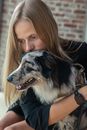 白人妇女深情地拥抱她的边境牧羊犬，捕捉到了陪伴的温馨时刻