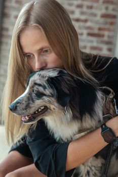 白人妇女深情地拥抱她的边境牧羊犬，捕捉到了陪伴的温馨时刻