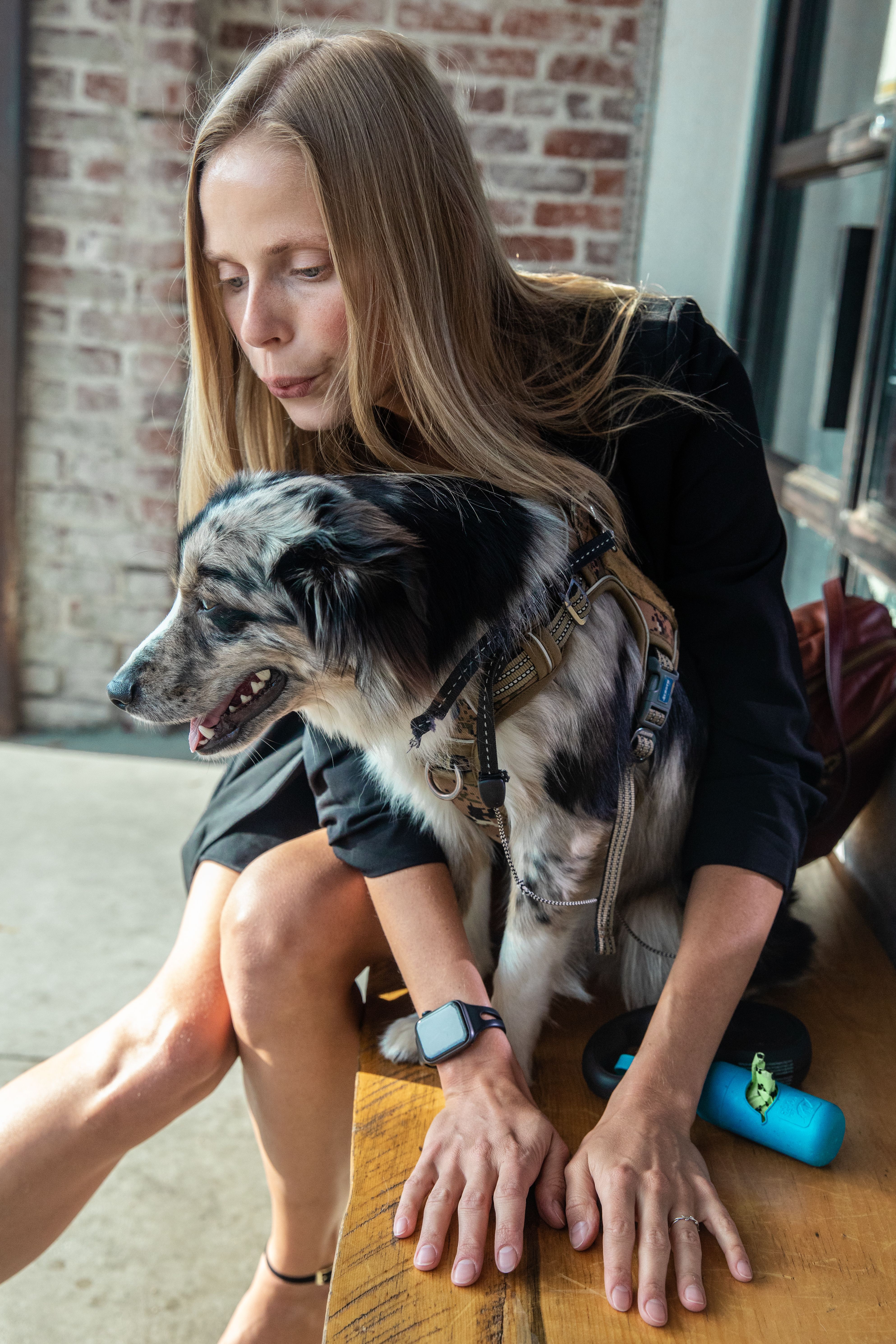 一位白人妇女在室内深情地拥抱着她的边境牧羊犬，展现了温馨的陪伴时刻