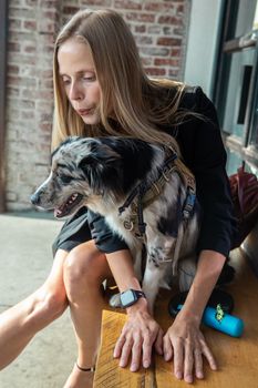 一位白人妇女在室内深情地拥抱着她的边境牧羊犬，展现了温馨的陪伴时刻