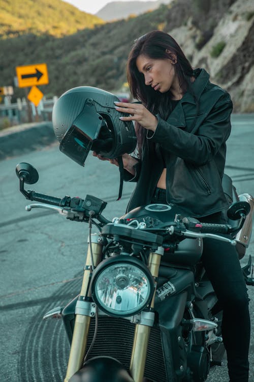 A Woman in Black Jacket Riding a Motorcycle