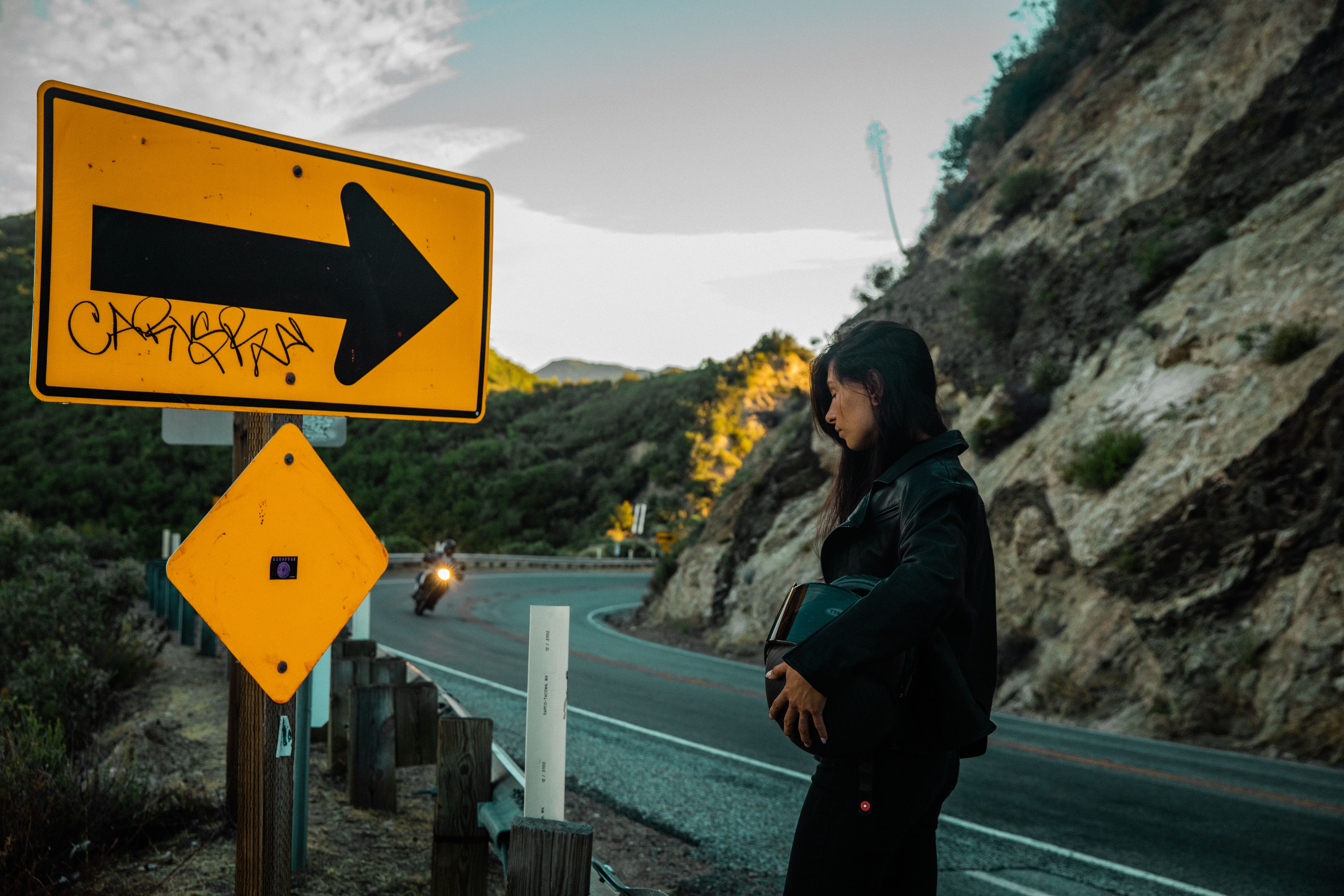 A Woman in a Black Jacket Standing on the Side of the Road · Free Stock ...