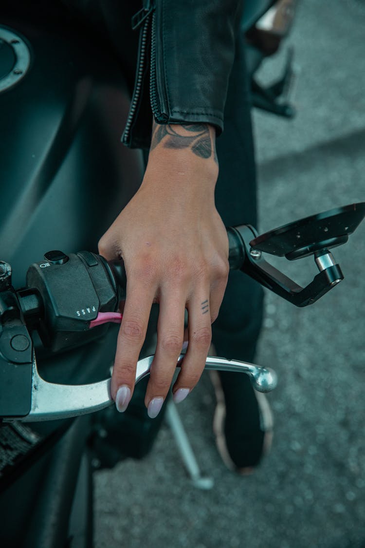 A Person's Hand On A Motorcycle Handle Bar