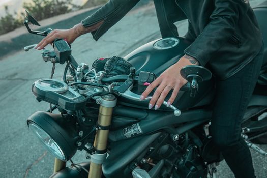 A Close Up of a Person in Black Leather Jacket Riding a Black Motorcycle