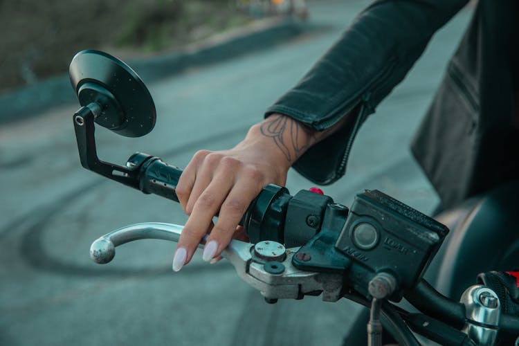 A Person Holding A Motorcycle Handle Bar